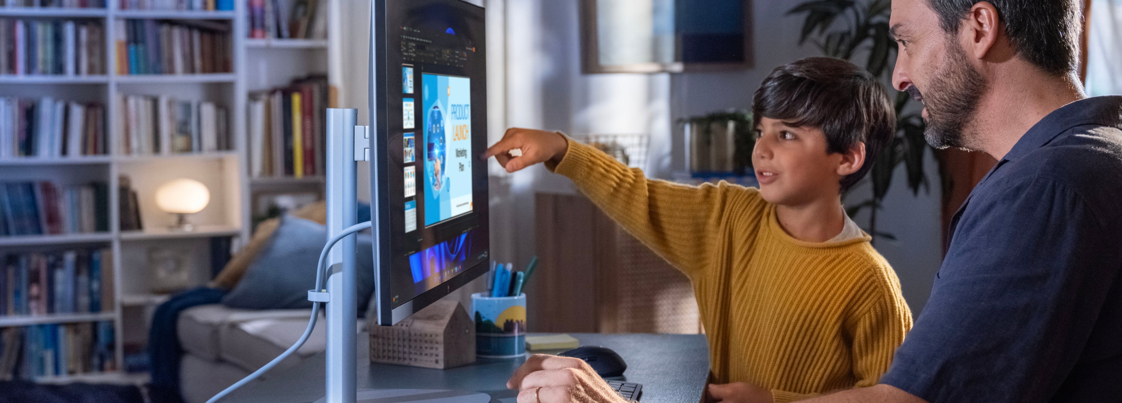 A man working from home on an HP EliteDesk AiO with his son by his side