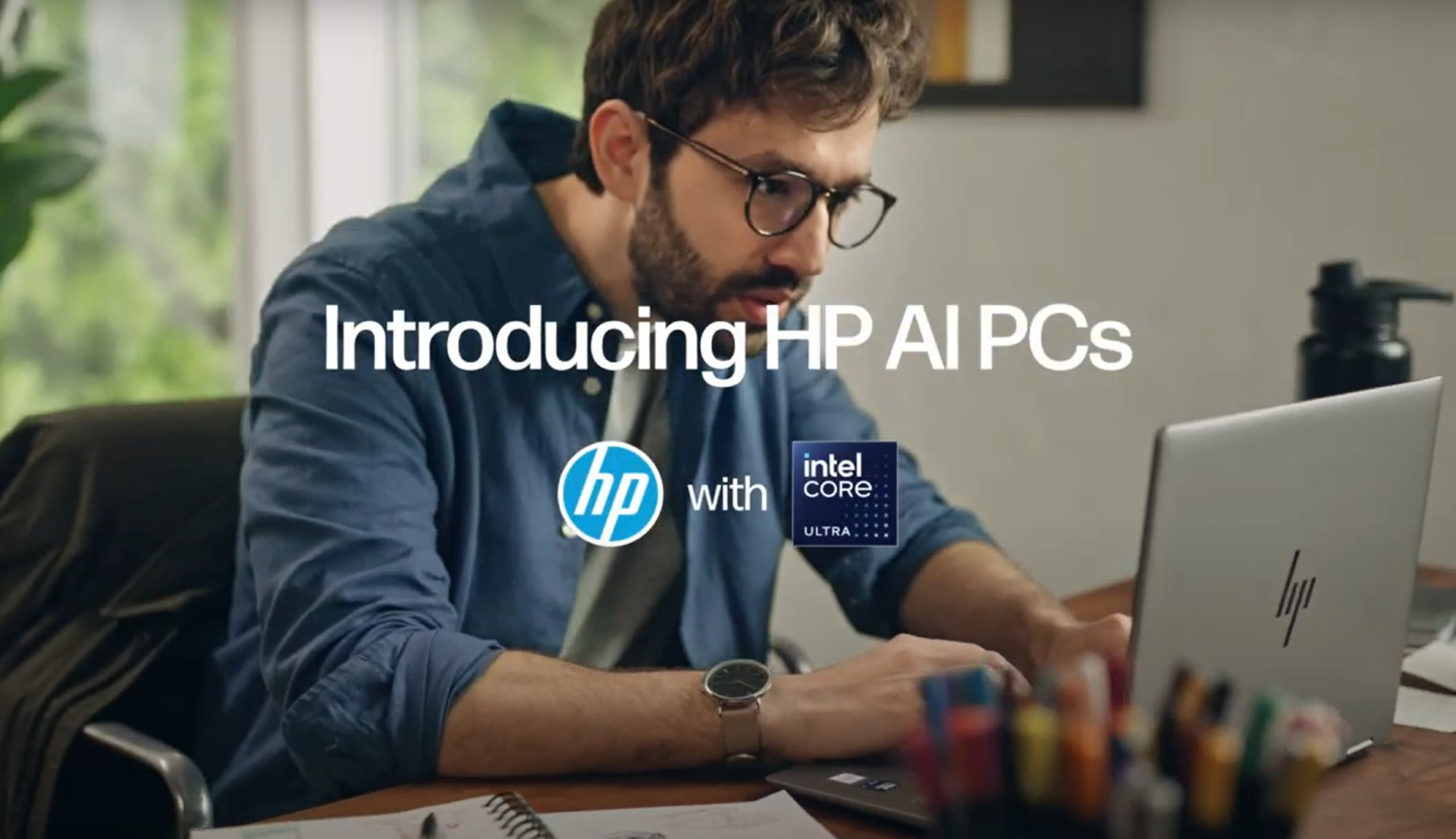 A man working on an HP Envy laptop in his home office