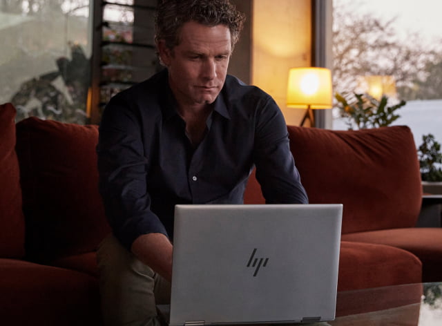 Man working on HP laptop from home in the evening