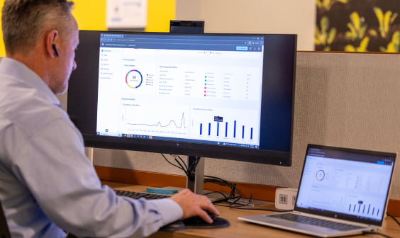 professional man at desk using HP laptop and HP curved display for data analysis