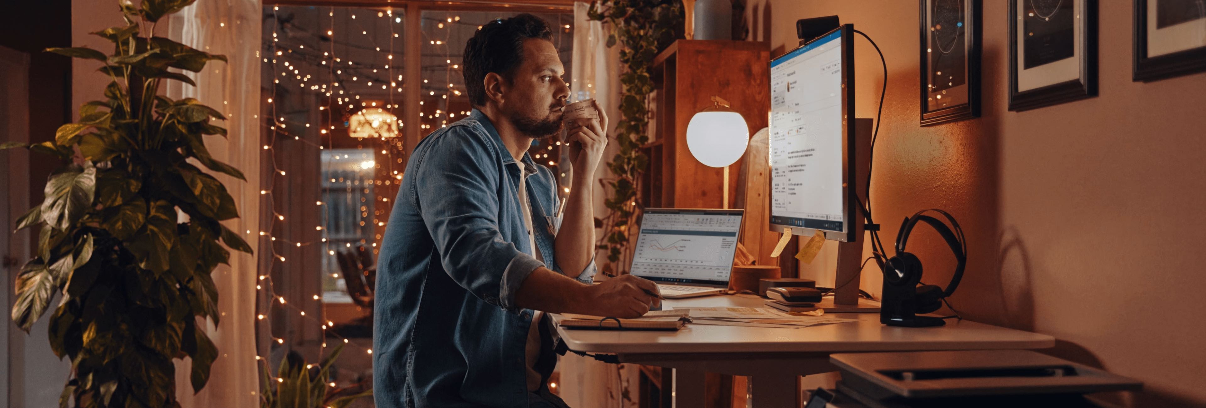 A man working on his HP monitor connected to an HP laptop.