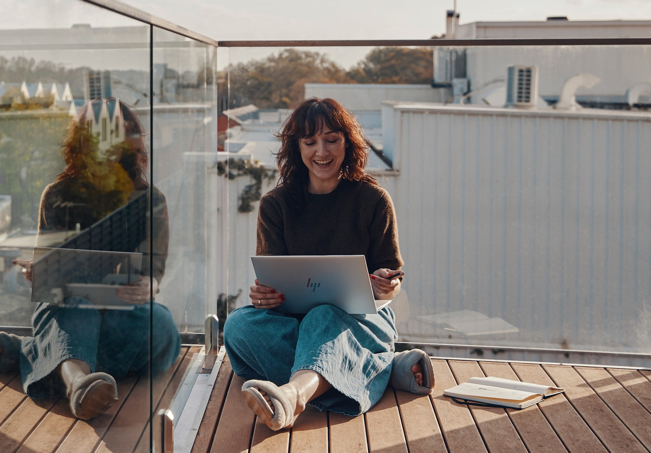 Woman sitting on the floor, holding an HP computer.