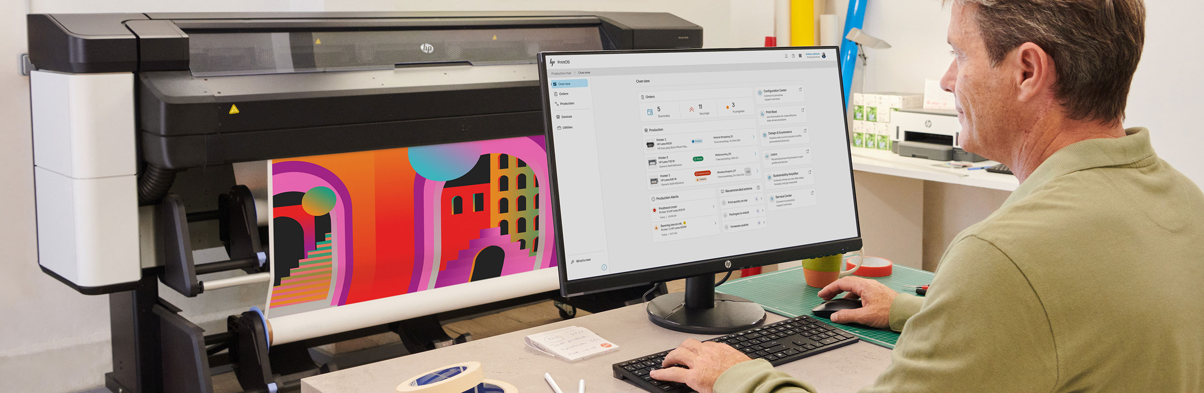 Person checking print software on an HP computer next to an HP Latex printer