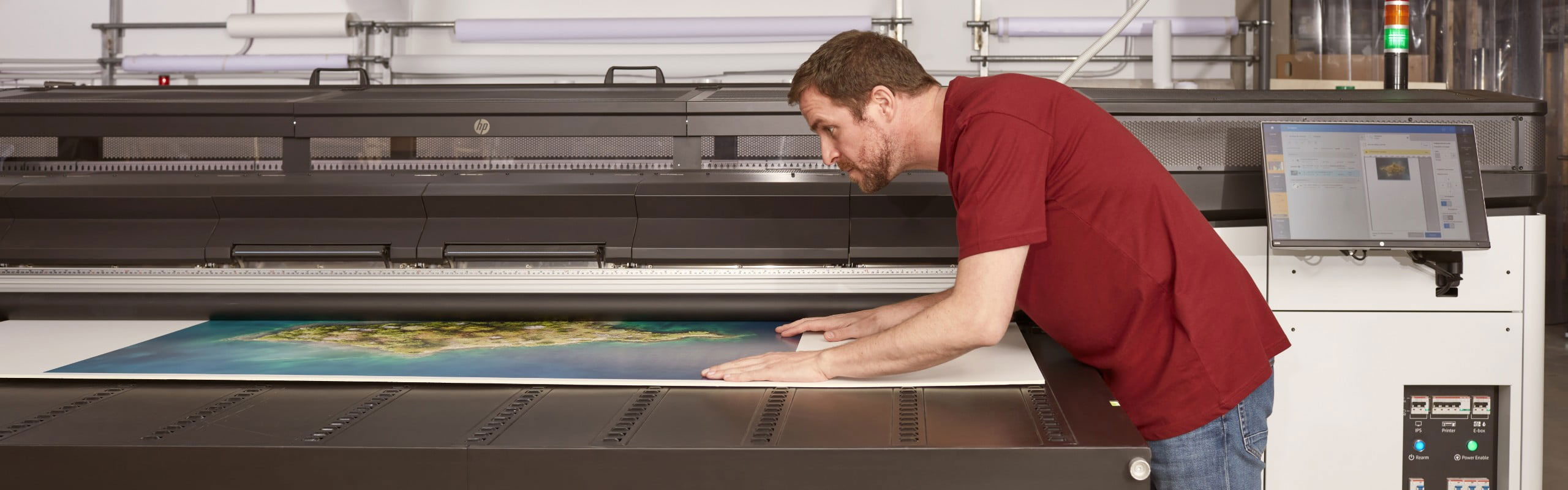 Person checking printed media coming out from an HP Latex R series printer
