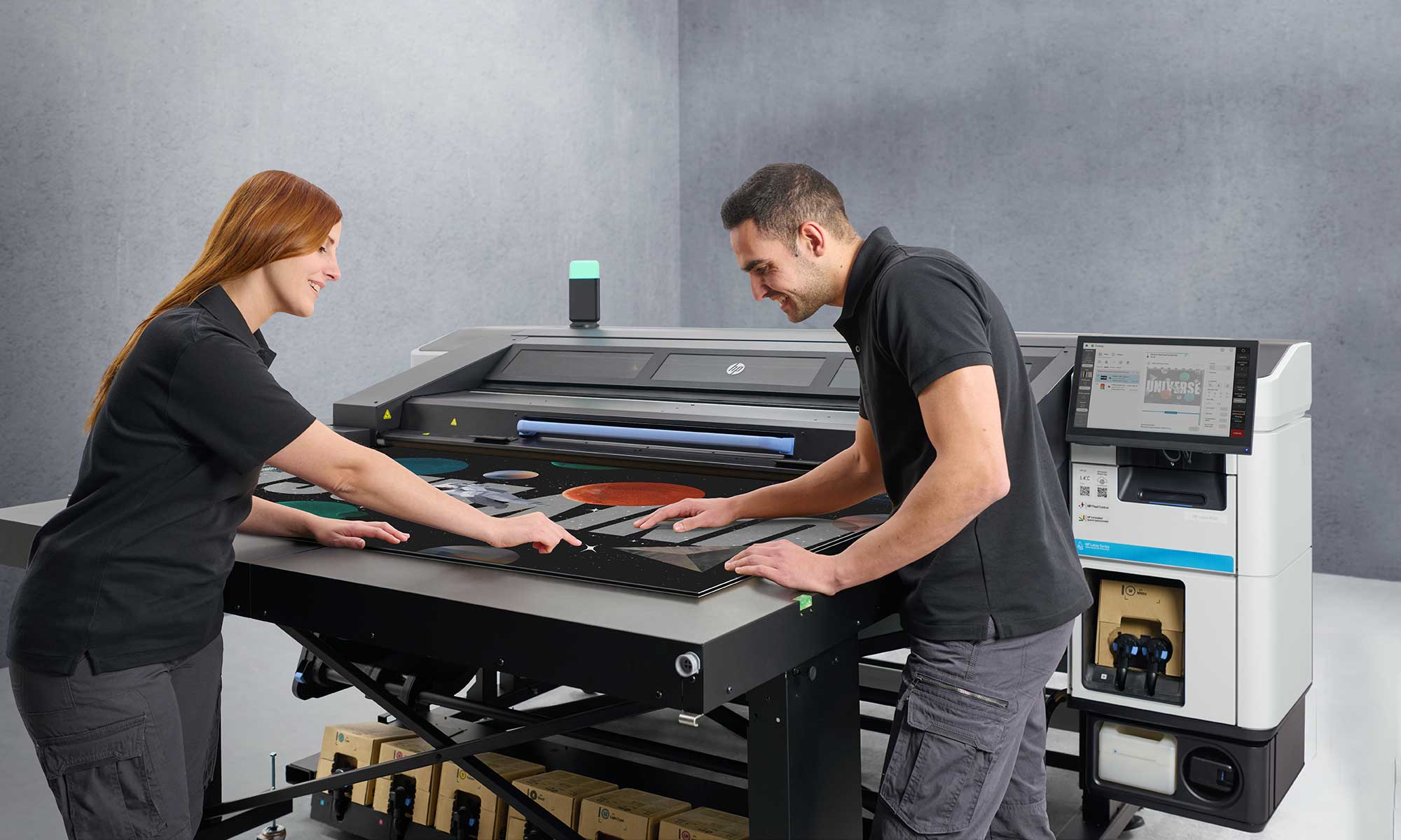 People checking printed media coming out of the HP Latex R530 printer