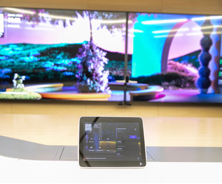 HP Poly touchscreen remote control on a conference room table