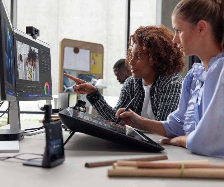 Two colleagues collaborating on a digital project using a computer and drawing tablet in a flexible, tech-enabled flexible workspace.