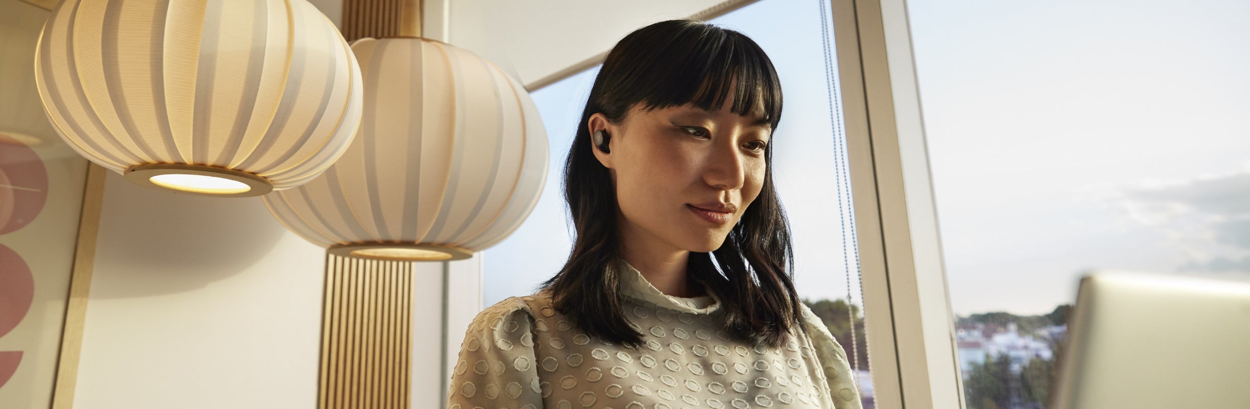 Woman working on laptop wearing earbuds