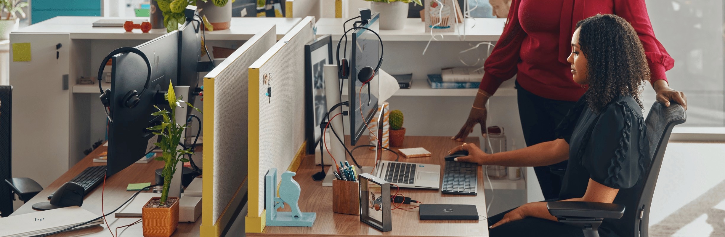 Workers helping at desktop workstation