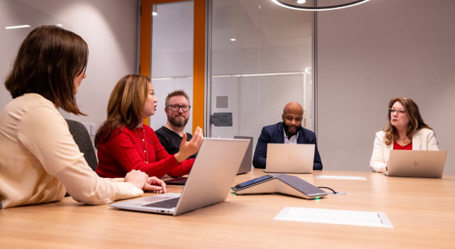 HP employees collaborating in meeting room.