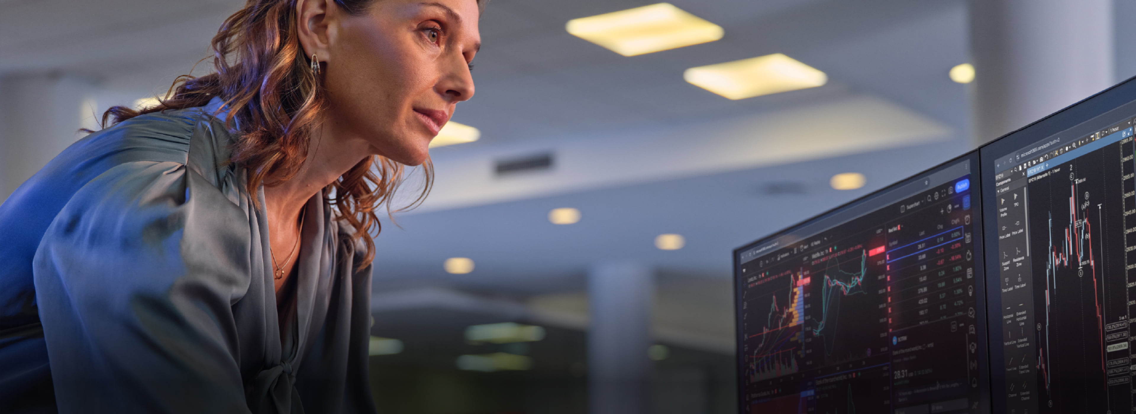 female IT professional looking at HP dual monitors analyzing data