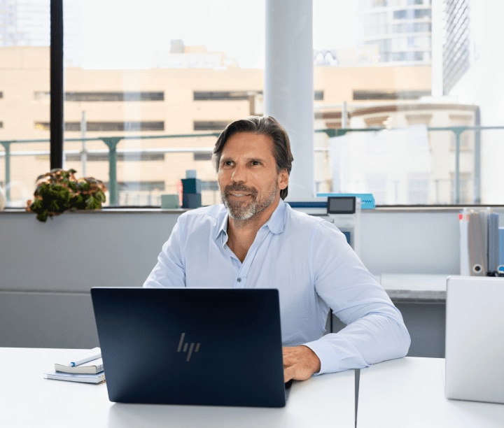 professional man at desk using HP laptop