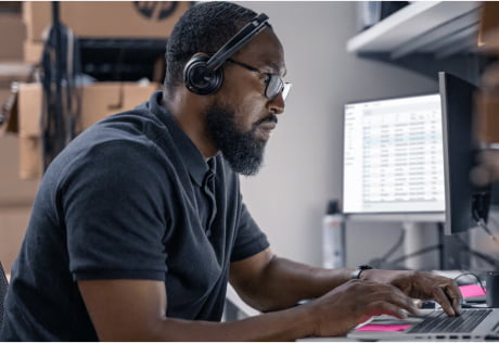 Person with headphones working on PC