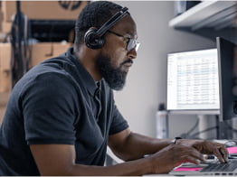 Person with headphones working on PC