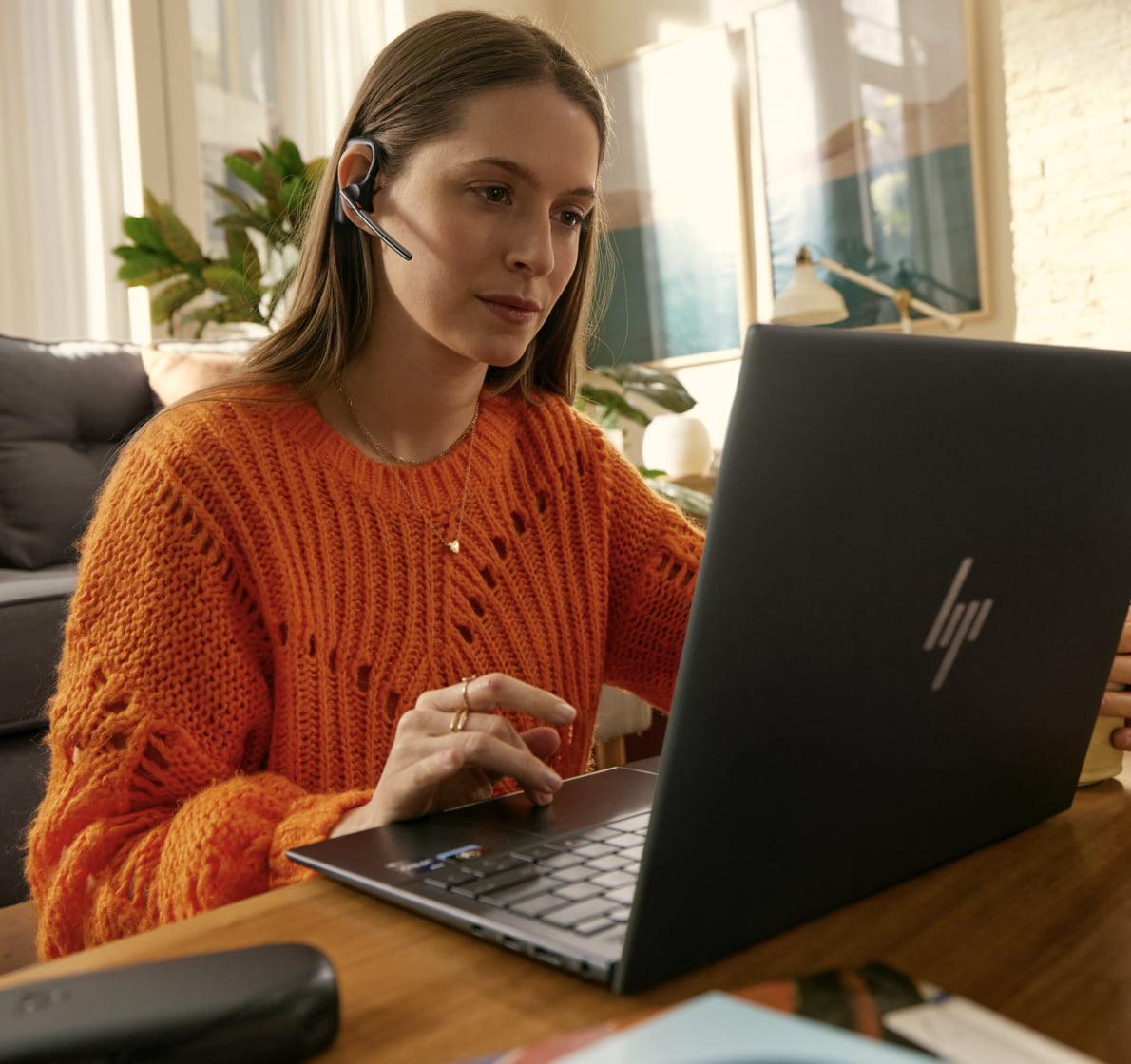 woman with HP Poly headset at HP latop using the touchpad
