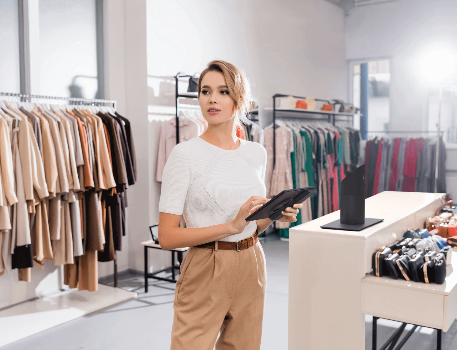 Saleswoman using an HP Engage point of sale system in mobile tablet mode at a clothing store