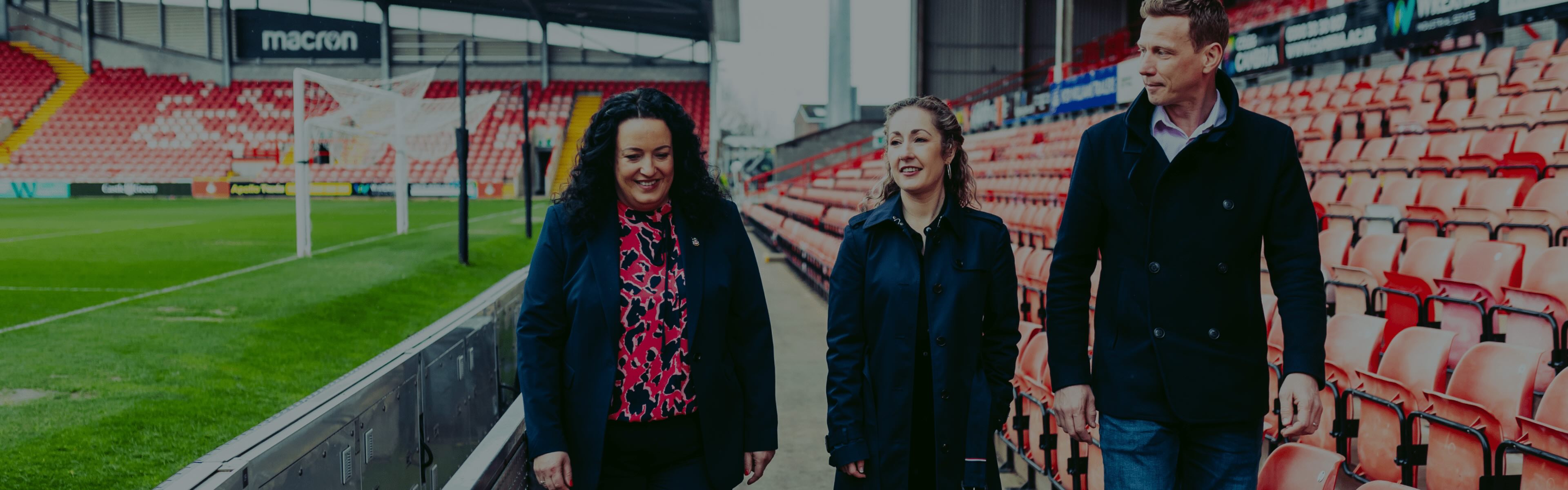 Three Wrexham employees walking through stadium
