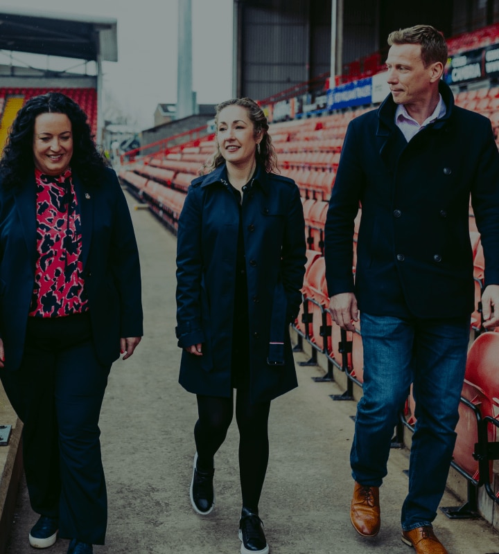 Three Wrexham employees walking through stadium
